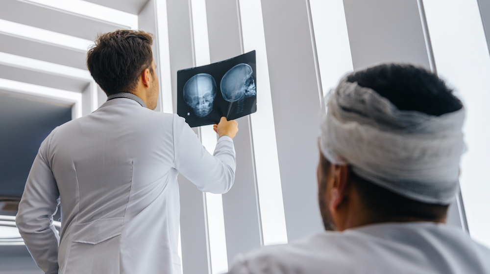 Young doctor man looking x-ray of the patient’s skull